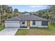 Charming single-story home featuring a striking yellow door, manicured lawn, and spacious driveway at 1117 Vernon Ave, Port Charlotte, FL 33948