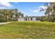Inviting single-story home with bright yellow front door, surrounded by lush green lawn and palm trees at 1117 Vernon Ave, Port Charlotte, FL 33948
