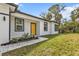 A close up front elevation of a house showing the beautiful yellow door and well-manicured lawn at 1117 Vernon Ave, Port Charlotte, FL 33948