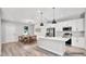 Modern kitchen and dining area featuring white cabinets, stainless steel appliances, an island and pendant lighting at 1117 Vernon Ave, Port Charlotte, FL 33948