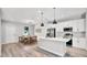Well-lit, modern kitchen and dining area featuring an island, stainless steel appliances, pendant lights, and an adjacent dining table at 1117 Vernon Ave, Port Charlotte, FL 33948
