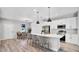 Modern kitchen with white cabinets, an island with seating, stainless steel appliances, and an adjacent dining area at 1117 Vernon Ave, Port Charlotte, FL 33948
