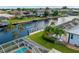Backyard view with canal access including dock, pool and screen lanai enclosure at 1118 Treasure Cay Ct, Punta Gorda, FL 33950