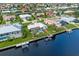 Aerial view of canal-front house featuring a private boat dock and enclosed pool area at 1118 Treasure Cay Ct, Punta Gorda, FL 33950