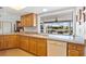Well-lit kitchen with granite countertops, wooden cabinetry, and a view to the backyard at 1118 Treasure Cay Ct, Punta Gorda, FL 33950