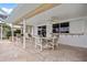 Covered outdoor patio with stylish furniture, fan and direct access to backyard at 1118 Treasure Cay Ct, Punta Gorda, FL 33950