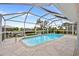 Inviting screened-in pool with canal views and lush landscaping around the house at 1118 Treasure Cay Ct, Punta Gorda, FL 33950