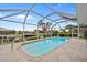 Screened-in pool area with paved deck, landscaping, and a view of the canal at 1118 Treasure Cay Ct, Punta Gorda, FL 33950