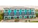 Three-story condos painted blue, with balconies, drive-under parking, and fenced yards with lush green grass at 11723 1St E St, Treasure Island, FL 33706