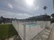 Community pool offers a refreshing escape, surrounded by a secure fence and palm trees for privacy at 11723 1St E St, Treasure Island, FL 33706