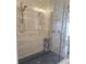 Modern glass shower with pebble tile flooring and multiple shower heads in renovated bathroom at 11723 1St E St, Treasure Island, FL 33706