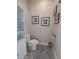 Comfortable toilet room with wood flooring and three framed pictures at 11723 1St E St, Treasure Island, FL 33706