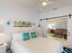 Bright bedroom featuring white walls, ceiling fan and a sliding barn door to the living room at 1286 Green Oak Trl, Port Charlotte, FL 33948