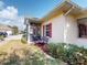 Charming home exterior with a screened lanai, decorative shutters, and a cozy bench in a well-manicured landscape at 1286 Green Oak Trl, Port Charlotte, FL 33948