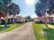 Street view of the villas with manicured lawn and tropical trees at 1286 Green Oak Trl, Port Charlotte, FL 33948