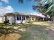 Side view of villa, featuring a screen porch, lush lawn and tropical trees at 1286 Green Oak Trl, Port Charlotte, FL 33948