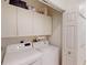 Bright laundry room with white cabinets, washer and dryer, and closet at 1286 Green Oak Trl, Port Charlotte, FL 33948