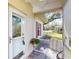Inviting porch with white-framed front door and comfortable chair overlooking the well-maintained neighborhood at 1286 Green Oak Trl, Port Charlotte, FL 33948