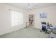 A bedroom with neutral walls and carpet with a bookshelf and a bright window at 1364 Ultramarine Ln, Punta Gorda, FL 33983