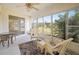 Enclosed sunroom with wicker furniture, offering serene views of the manicured backyard at 1364 Ultramarine Ln, Punta Gorda, FL 33983