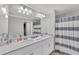 Bright bathroom features a double sink vanity, neutral color palette and shower with blue striped curtain at 14184 Heritage Landing Blvd # 516, Punta Gorda, FL 33955