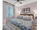 Comfortable bedroom featuring a queen bed with floral bedding, wicker headboard, a ceiling fan and neutral color palette at 14184 Heritage Landing Blvd # 516, Punta Gorda, FL 33955