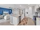 Kitchen with island and bar seating that opens to a living room with a blue accent wall and ceiling fan at 14184 Heritage Landing Blvd # 516, Punta Gorda, FL 33955