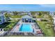 Aerial view of a pool and pavilion with lounge chairs, lush landscaping, and palm trees in a residential community at 14184 Heritage Landing Blvd # 516, Punta Gorda, FL 33955