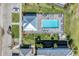 Top-down view of a community pool area with a covered pavilion, surrounded by lounge chairs and lush landscaping at 14184 Heritage Landing Blvd # 516, Punta Gorda, FL 33955