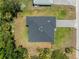 Aerial view of a home with a dark roof, showing its position on a property surrounded by tropical foliage at 1790 New London St, North Port, FL 34288