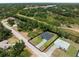 Aerial view of a single-Gathering home with an expansive yard, driveway, and lush green surroundings at 1790 New London St, North Port, FL 34288