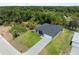 An aerial shot showcasing a grey home with a lush, green surrounding landscape and long driveway at 1790 New London St, North Port, FL 34288
