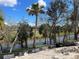 A landscape view of trees along the water in the backyard and dirt in the foreground at 1790 New London St, North Port, FL 34288
