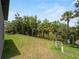 Spacious backyard featuring green grass, lush trees and lake at 1790 New London St, North Port, FL 34288