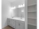 Bathroom vanity with double sinks, modern lighting, tile floors, and built-in shelving at 1790 New London St, North Port, FL 34288