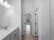 Bright hallway view into bathroom featuring a modern vanity and wood-look tile flooring at 1790 New London St, North Port, FL 34288