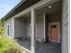 Inviting front porch with gray siding, stone accents, and a vibrant door at 1790 New London St, North Port, FL 34288