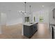 Open-concept kitchen with island, pendant lights, and seamless flow to living and dining areas at 1790 New London St, North Port, FL 34288