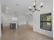 Bright, open-concept living space with wood-look tile, white walls, and natural light at 1790 New London St, North Port, FL 34288