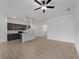 Open-concept living space with ceiling fan, neutral paint, and view into the kitchen with breakfast bar at 1790 New London St, North Port, FL 34288
