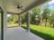 Covered patio with ceiling fan overlooking a private backyard and lush greenery at 1790 New London St, North Port, FL 34288