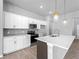 Bright kitchen island with pendant lighting, quartz counters, and stainless steel appliances at 1818 New London St, North Port, FL 34288