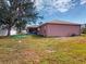 Spacious backyard featuring lush lawn, mature trees, and a screened-in patio, offering a private outdoor space at 20370 Mount Prospect Ave, Port Charlotte, FL 33952