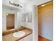 Bright bathroom featuring a single sink vanity, large mirror, and a walk-in closet at 20370 Mount Prospect Ave, Port Charlotte, FL 33952