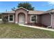 Inviting home featuring a white front door with an arched entryway, complemented by manicured landscaping at 20370 Mount Prospect Ave, Port Charlotte, FL 33952