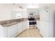 Bright kitchen featuring white cabinets, stainless steel appliances, and a convenient breakfast bar at 20370 Mount Prospect Ave, Port Charlotte, FL 33952