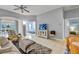 Cozy living room with tile flooring, neutral walls, ceiling fan and view into the main bedroom at 2175 Lynx Run, North Port, FL 34288