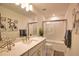 Modern bathroom with a granite countertop, tub with glass door, and decorative art at 2208 Darley Oak Way, North Port, FL 34289