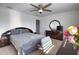 Cozy bedroom featuring soft gray linens, a ceiling fan, and a dark wood dresser with round mirror at 2208 Darley Oak Way, North Port, FL 34289