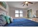 Stylish bedroom showcasing a comfortable blue bed, shuttered windows, and decorative art at 2208 Darley Oak Way, North Port, FL 34289